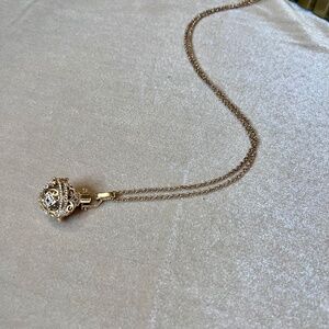 Whimsical necklace with chime bell inside, gold and crystal